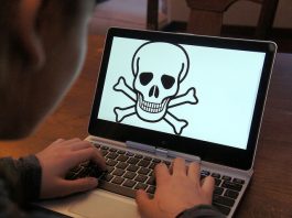 Child using laptop displaying skull and crossbones warning symbol. Protecting children from internet abuse.