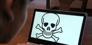 Lindungi Kanak-Kanak dari Penyalahgunaan Internet Child using laptop displaying skull and crossbones warning symbol. Protecting children from internet abuse.