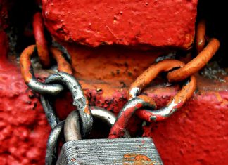 Lihat Kata Laluan Laman Web di Google Rusty padlock and chain secured to a red brick wall. The padlock is labeled "Master.