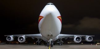Aplikasi Amaran Harga Tiket Kapal Terbang Murah Front view of a Boeing 747 cargo plane at night on a runway.