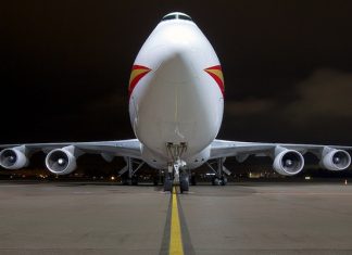 Aplikasi Amaran Harga Tiket Kapal Terbang Murah Front view of a Boeing 747 cargo plane at night on a runway.
