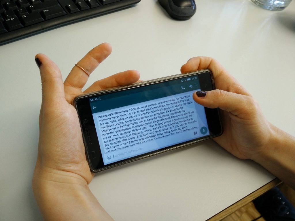 Hands holding smartphone displaying a German warning message.