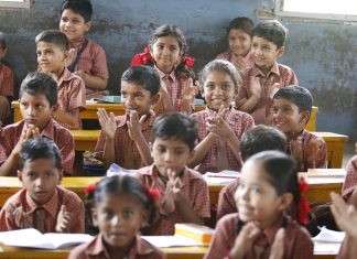 Dana Transformasi Kelas Biasa ke Kelas Frog Happy schoolchildren in a classroom, clapping enthusiastically.
