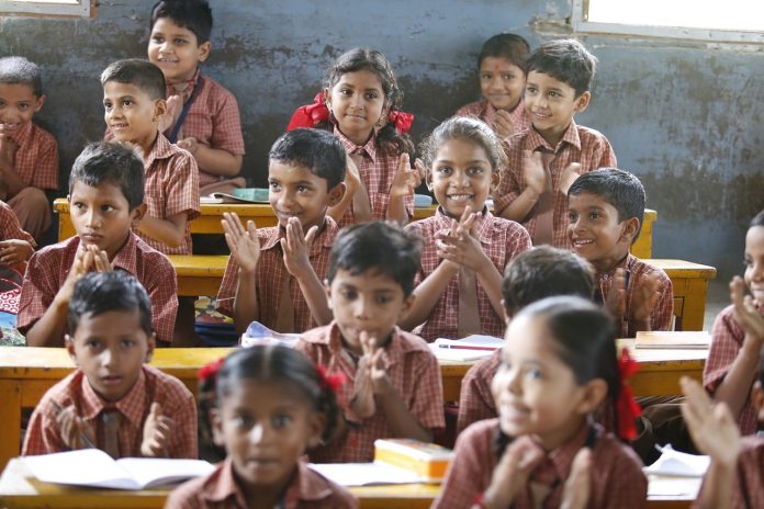 Dana Transformasi Kelas Biasa ke Kelas Frog Happy schoolchildren in a classroom, clapping enthusiastically.