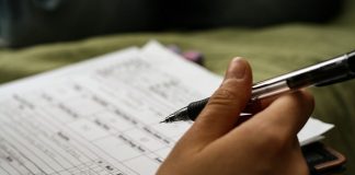 Cara Mengisi Borang dalam Format PDF di Komputer Close-up of a hand filling out a PDF form with a pen. "Advancement Points" and other relevant data are visible.