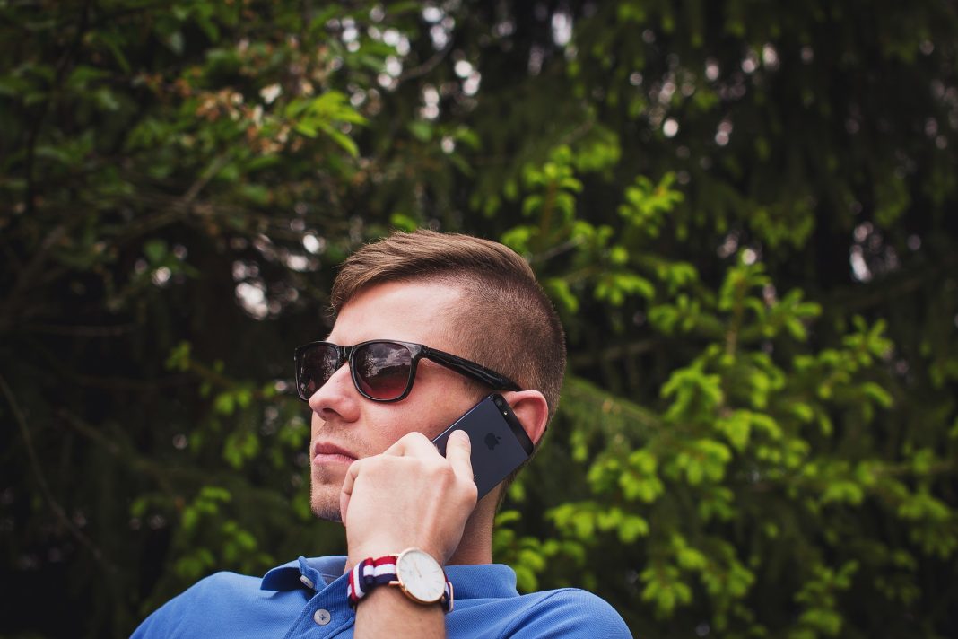 Kenal Nombor Telefon Dahulu Sebelum Jawab Dengan Apps Ini Man on phone outdoors, wearing sunglasses