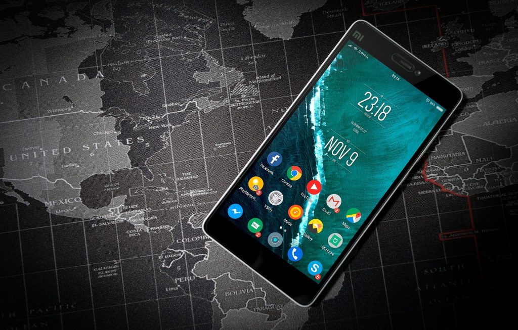 Smartphone displaying Chrome browser and other apps on a world map.